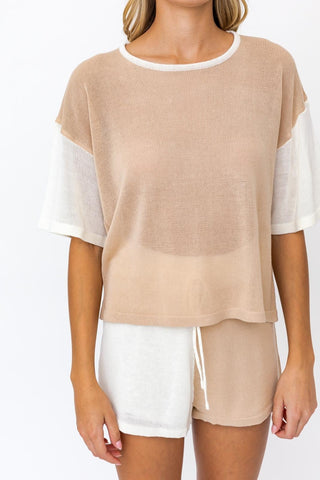 Model wearing tan and cream knit set. Model standing forward towards the camera and showing the outfit close up.